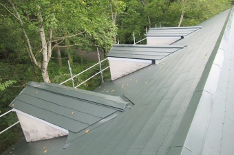 ムラなくモスグリーン色に仕上がった施工後のスレート屋根